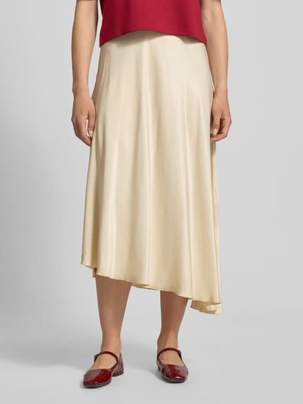 Frauenmodel trägt Midirock aus Viskose-Mix Modell 'Bethanie' von MSCH Copenhagen, Asymmetrischer-Look, unifarben, elastischer Bund, Ganzkörperansicht von vorne.