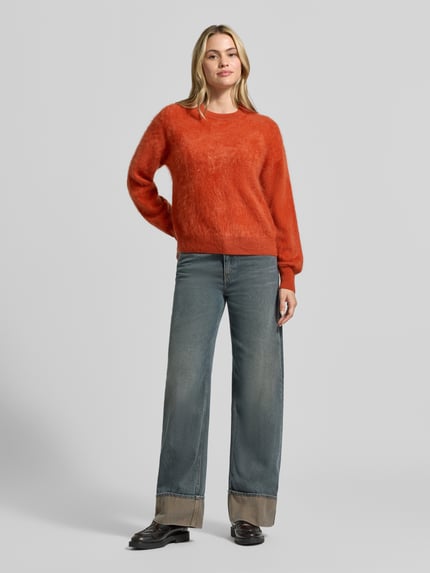 Frauenmodel trägt Regular Fit Pullover aus reinem Kaschmir von Jake*s Casual in leuchtendem Orange mit feiner Textur, Ganzkörperansicht von vorne.