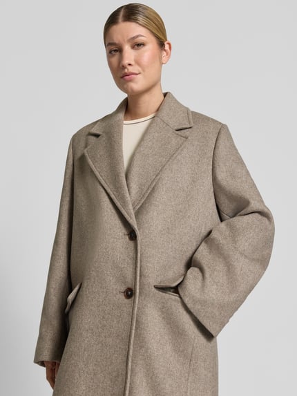 Frauenmodel trägt Mantel mit Pattentaschen Modell 'WALDRON' von DRYKORN in Beige, Baumwoll-Mix, Nahaufnahme Oberkörper.