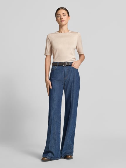 Frauenmodel trägt Regular Fit Pullover in Strick-Optik Modell "LULS" von ICHI in Beige, kurzärmlig, Viskose-Mix, Ganzkörperansicht von vorne.