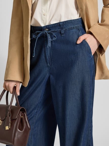 Frauenmodel trägt Wide Leg Jeans mit Bindegürtel Modell 'Wendy' von MAC, Baumwoll-Lyocell-Mix, dunkelblau, Nahaufnahme Hüftbereich.