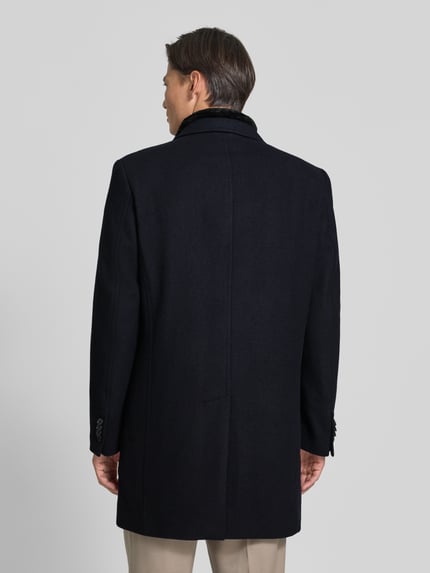 Männermodel trägt Regular Fit Mantel aus Woll-Mix von HECHTER PARIS in Schwarz, strukturierte Oberfläche, Rückenansicht, Ganzkörperansicht Rückansicht. Herren Mantel mit Reverskragen, Stehkragen, Knopfleiste, 95 cm Rückenlänge, 43 cm Schulterbreite, 57 cm Brustweite, 67 cm Ärmellänge.