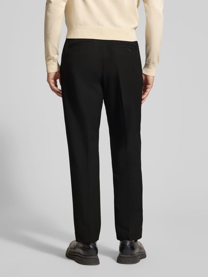 Mężczyzna nosi Regular Fit Chino mit Viskose-Anteil von Selected Homme, jednolity czarny kolor, kieszenie z tyłu, splot twill, mieszanka materiałów z dodatkiem wiskozy, krój regular fit, gładka tekstura, widok całej sylwetki z tyłu.