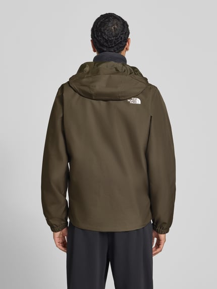 Męski model nosi Regular Fit Jacke mit Logo-Print Modell 'Quest' od The North Face w kolorze oliwkowym, gładka faktura, Kaptur ze stójką, wpuszczane kieszenie, zamek błyskawiczny, Długość tyłu w rozmiarze M: 72 cm, szerokość ramion w rozmiarze M: 46 cm, szerokość klatki piersiowej w rozmiarze M: 60 cm, długość rękawów w rozmiarze M: 69 cm, widok całej sylwetki od tyłu.