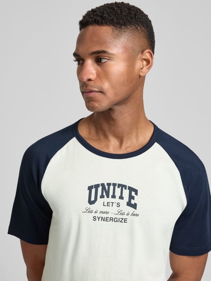 Männermodel trägt Regular Fit T-Shirt aus reiner Baumwolle von s.Oliver RED LABEL, Two Tone Design, Statement Print, Nahaufnahme Oberkörper.