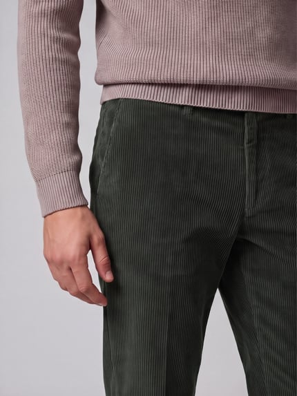 Männermodel trägt Regular Fit Cordhose aus Baumwollmix von Hiltl in Olivgrün, feine Cordstruktur, Nahaufnahme Oberkörper, Cordmaterial.