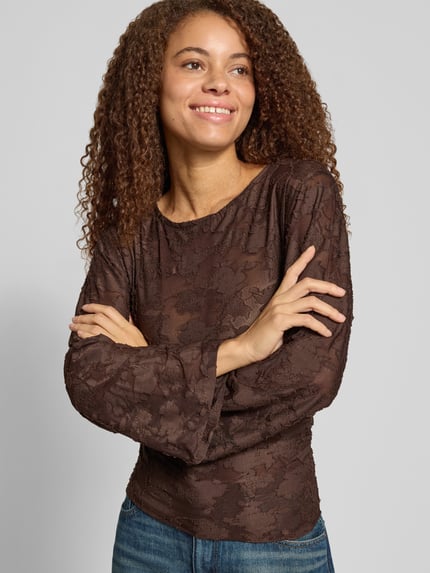 Frauenmodel trägt Langarmshirt mit Mesh Ausbrenner-Effekt von ONLY, rundhals, spitzen Muster, braun, Oberkörperansicht von vorne.