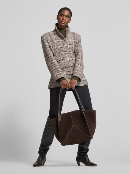 Frauenmodel trägt Shopper aus echtem Leder von Victoria Beckham in Dunkelbraun, klare Linien, Label-Detail, strukturierte Oberfläche, Ganzkörperansicht von vorne. Damen Shopper aus echtem Leder, Hauptfach mit Magnetverschluss, schmale Schulterriemen, Steckfach innen, Maße: 51x31x18 cm.