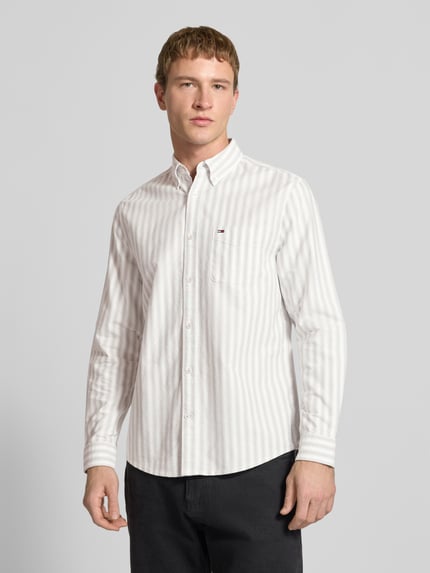 Männermodel trägt Regular Fit Freizeithemd aus reiner Baumwolle von Tommy Jeans, Optik: Allover-Muster, Nahaufnahme Oberkörper.