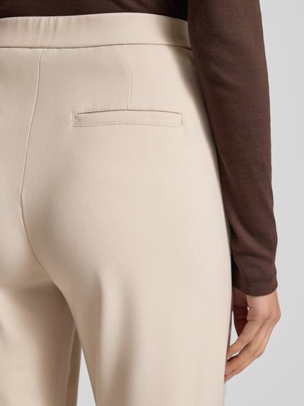 Frauenmodel trägt Wide Leg Stoffhose mit elastischem Bund Modell 'PALINA' von Raffaello Rossi im Material-Mix mit Viskose-Anteil, Crêpe-Struktur, französische Eingrifftaschen und Gesäßtaschen, Nahaufnahme Rückansicht.