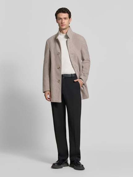 Männermodel trägt Daunenjacke Modell 'Fynn' mit Stehkragen von Strellson, unifarben matt, strukturierte Optik, sichtbare Knöpfe und Taschen, Ganzkörperansicht von vorne.