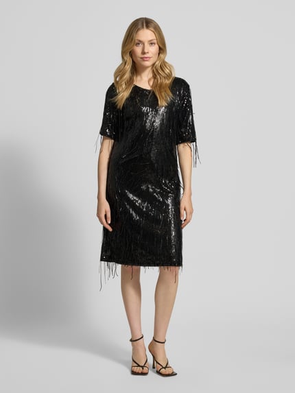 Frauenmodel trägt Knielanges Kleid mit Pailletten und Fransen von Milano Italy in Schwarz, Gerader-Schnitt, Rundhalsausschnitt, Ganzkörperansicht von vorne.