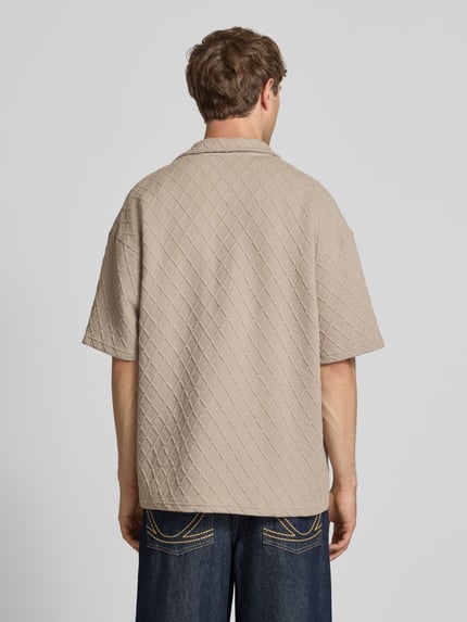 Männermodel trägt Modern Fit Freizeithemd mit Logo-Stitching Modell 'Jovren' von Pegador, Strukturmuster, Material-Mix, sandfarben, Ganzkörperansicht Rückansicht. Kontext: Herren Freizeithemd, Kentkragen, Knopfleiste, Rückenlänge bei Größe M 72 cm, Schulterbreite 61 cm, Ärmellänge 24 cm.