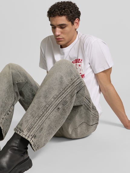 Männermodel trägt Loose Fit Jeans aus Baumwoll-Mix von Diesel in grau mit Label-Detail, 5-Pocket-Design, Ganzkörperansicht von vorne. Innenbeinlänge 80 cm, Bundweite 44 cm.