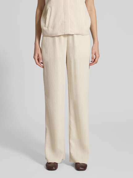 Kobiece model prezentuje spodnie materiałowe Wide Fit Stoffhose aus Viskose-Mix Modell 'Mucia' od OPUS PANTS, fakturowany wzór, mieszanka wiskozy, elastyczny pas, kremowy kolor, szerokość w rozmiarze 36: 37 cm, długość wewnętrzna nogawki w rozmiarze 36: 81 cm, widok na całe ciało z przodu.
