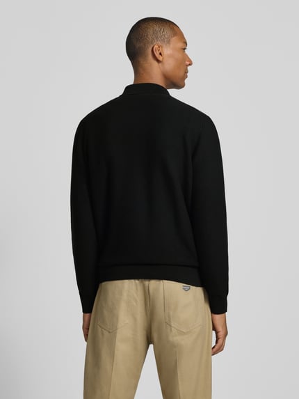 Mężczyzna nosi Regular Fit Poloshirt aus reiner Baumwolle von Lacoste w kolorze czarnym, jednolita tekstura, widok całej sylwetki z tyłu