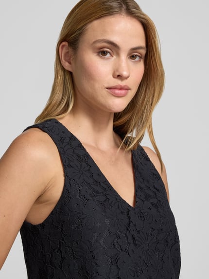 Frauenmodel trägt Regular Fit Trägertop aus Baumwoll-Mix Modell 'HONEY' von Vero Moda mit Spitzen-Muster, Optik: Unifarben, V-Ausschnitt, breite Träger, Materialverarbeitung Spitze, Nahaufnahme Oberkörper.