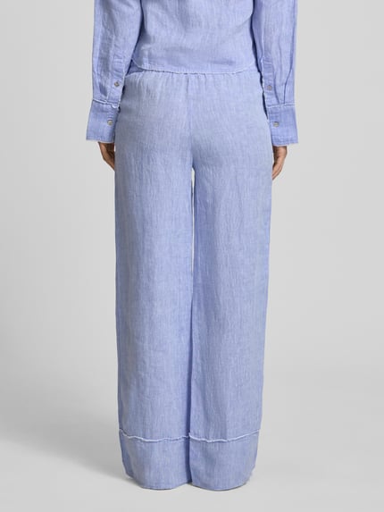 Frauenmodel trägt Leinenhose mit elastischem Bund und Tunnelzug von Christian Berg Woman, Reines Leinen, Weites Bein, Ganzkörperansicht Rückansicht.