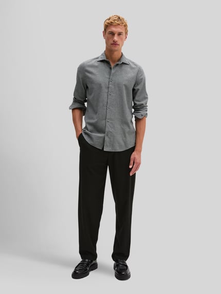 Männermodel trägt Regular Fit Freizeithemd mit geknöpften Manschetten von MARC O'POLO aus reiner Baumwolle, feines Webmuster, Ganzkörperansicht von vorne.