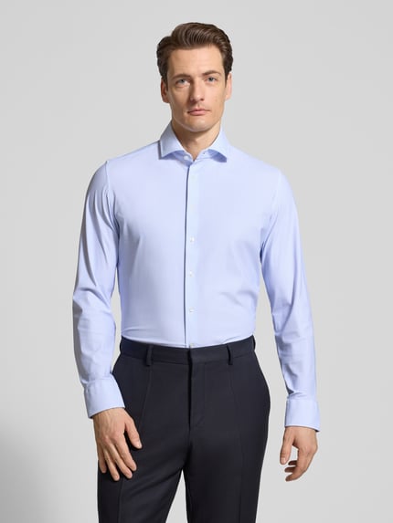 Männermodel trägt Slim Fit Business-Hemd mit Haikragen von Seidensticker, Elastischer-Material-Mix, Knopfleiste, Ganzkörperansicht von vorne. Rückenlänge bei Größe 40: 76 cm, Schulterbreite bei Größe 40: 44 cm, Ärmellänge bei Größe 40: 67 cm.