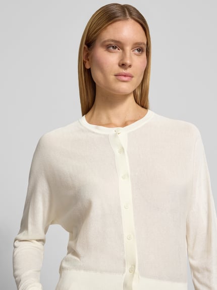 Frauenmodel trägt Strickjacke mit Rundhalsausschnitt Modell 'Desela' von OPUS aus Viskose-Mix, Regular-Fit, Knopfleiste, Nahaufnahme Oberkörper.