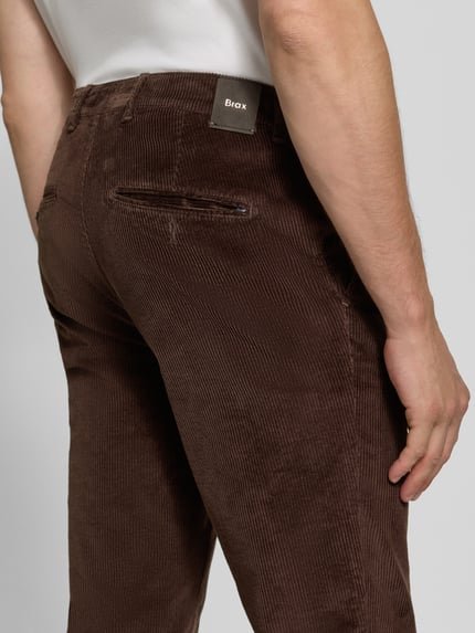 Männermodel trägt Modern Fit Cordhose aus Baumwoll-Mix Modell 'Fabio' von Brax in Dunkelbraun, feine Rippenstruktur, Nahaufnahme Rückansicht, Herren Schmale Hose von Brax.