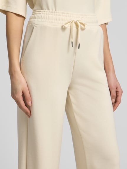 Frauenmodel trägt Wide Leg Sweatpants mit elastischem Bund von Soyaconcept in Beige, Material-Mix mit Modal-Anteil, Nahaufnahme Hüfte und Beine.