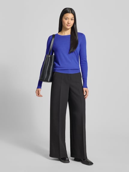 Vrouwenmodel draagt Strickpullover mit gerippten Abschlüssen van Christian Berg Woman in kobaltblauw, slim fit, viscosemix, lange mouw, rond hals, gecombineerd met zwarte wijde broek, volledig vooraanzicht.