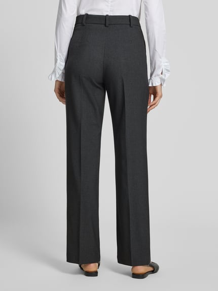 Frauenmodel trägt Straight Fit Hose mit viskose-Anteil Modell 'Bergen' von MANGO in Dunkelgrau, Bügelfalten, elastischer Stoff, Ganzkörperansicht Rückansicht.