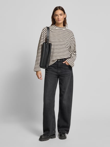Modelka kobieca nosi Regular Fit Langarmshirt aus reiner Baumwolle od Marc O'Polo, cienkie czarno-białe paski, dzianina, widok całej sylwetki z przodu.