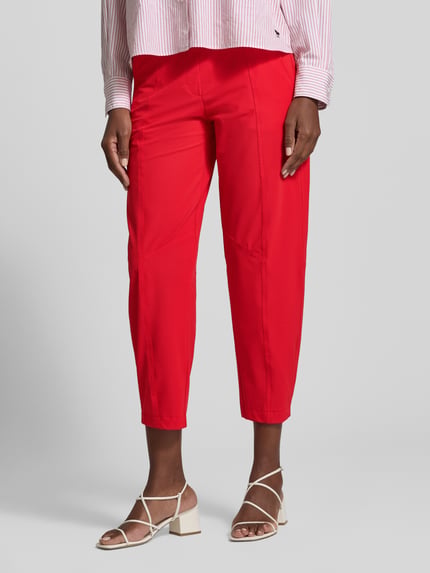 Frauenmodel trägt unifarbene rote Slim Fit Hose mit elastischem Label-Bund Modell 'EDEN' von Cambio, Cropped-Länge, Ganzkörperansicht von vorne.