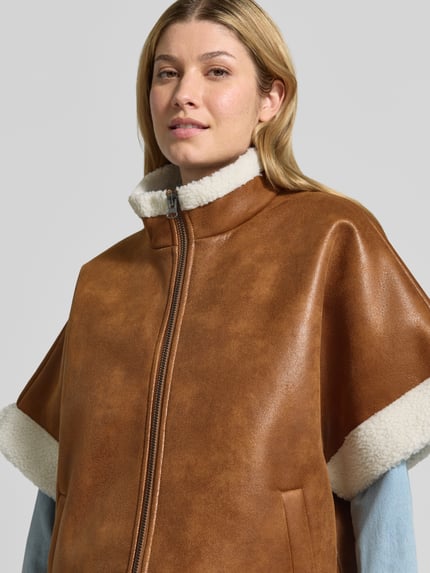 Vrouwenmodel draagt Jacke in Leder-Optik mit Stehkragen und 1/2-Arm van LOLLYS LAUNDRY, bruine lederlook, teddy voering, ritssluiting, steekzakken, regular fit, detailopname bovenlichaam.