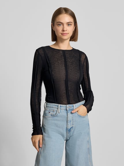 Kobiece model prezentuje bluzkę z długim rękawem Slim Fit Longsleeve in semitransparentem Design Modell 'Belma' od Topshop, mieszanka bawełny elastycznej, krój slim fit, półprzezroczysty materiał, okrągły dekolt, długość tyłu w rozmiarze S: 56 cm, ciemny kolor, teksturowany materiał, widoczne szwy, gładkie powierzchnie, całkowite ujęcie przodu.