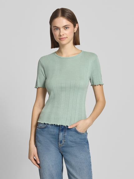 Vrouwenmodel draagt Slim Fit T-shirt uit katoenmix model 'TENNA' van Only, look: effen, ronde hals, korte mouw, rompzoom met frill, katoenmix. Nahaufnahme Oberkörper.