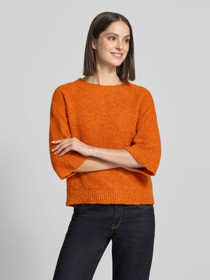 Vrouwenmodel draagt gebreide pullover met 3/4-mouw van Rich & Royal, oranje Materiaalmix met wol, regular fit, ronde hals, ruglengte maat S 56 cm, mouwlengte maat S 20 cm, Ganzkörperansicht van voren.