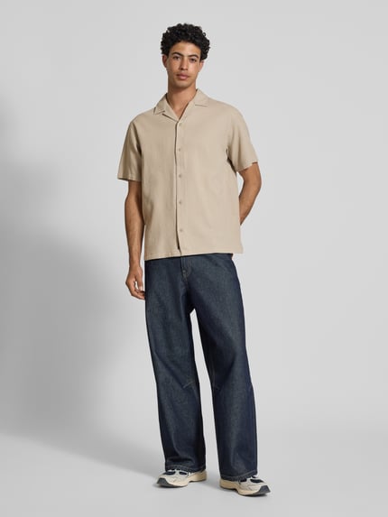 Männermodel trägt Regular Fit Freizeithemd mit Strukturmuster Modell 'Global' von Jack & Jones, beige Farbe, Ganzkörperansicht von vorne.