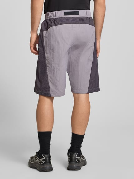 Männermodel trägt Shorts mit Logo und Gürtel von The North Face in Grau mit elastischem Bund, Herren Regular-Fit, Rückansicht.