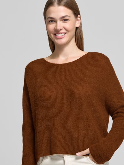 Frauenmodel trägt Oversized Wollpullover aus Alpaka-Mix von DRYKORN in Braun, Ripp-Optik, weiter Schnitt, Nahaufnahme Oberkörper.