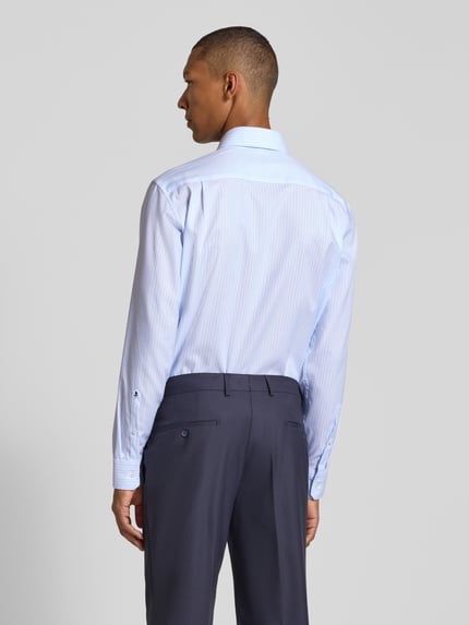 Männermodel trägt hellblaues Regular Fit Businesshemd aus reiner Baumwolle Modell 'New Kent' von Seidensticker, Ganzkörperansicht Rückansicht, Herren Businesshemd von Seidensticker.