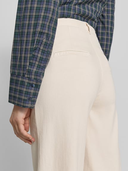 Frauenmodel trägt Hose mit Bügelfalten und Eingrifftaschen von SEDUCTIVE, Leinen-Baumwoll-Mix, weite Beine, Gesäßtaschen, Detailaufnahme Rückansicht.