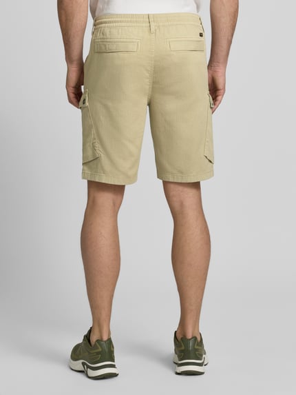 Mannenmodel draagt Shorts mit Cargotaschen und Tunnelzug van PME Legend in beige, puur katoen, regular fit, cargozakken, tunnelkoord. Ganzkörperansicht Rückansicht.