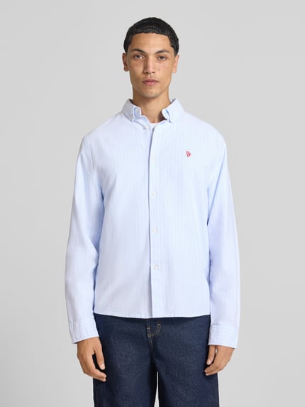 Männermodel trägt Regular Fit Freizeithemd aus reiner Baumwolle von REVIEW in Hellblau mit Knopfleiste, Button-Down-Kragen, Ganzkörperansicht von vorne.