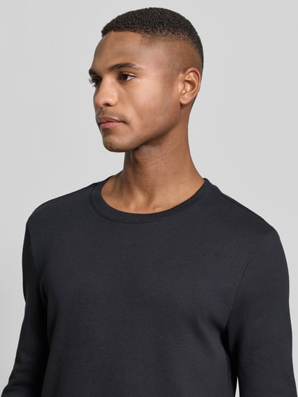 Männermodel trägt Longsleeve mit Strukturmuster und Rundhalsausschnitt von MCNEAL in Dunkelgrau, Baumwoll-Mix mit Stretch-Anteil, Slim Fit, Nahaufnahme Oberkörper.