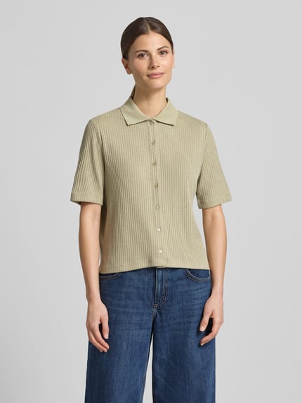 Modelka nosi Regular Fit Poloshirt mit durchgehender Knopfleiste von OPUS, mieszanka wiskozy z dodatkiem streczu, krój regular fit, model 'Somelly', długość tyłu w rozmiarze 36: 54 cm, jasny beż, subtelna struktura, gładka faktura, przód z listwą guzikową, całkowity widok z przodu.