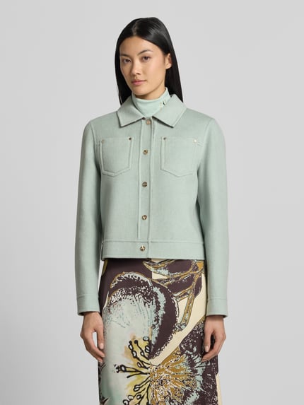 Frauenmodel trägt Wendejacke mit Knopfleiste und Brusttaschen von Marc Cain in Mintgrün aus Baumwolle, Regular Fit, Ganzkörperansicht von vorne.