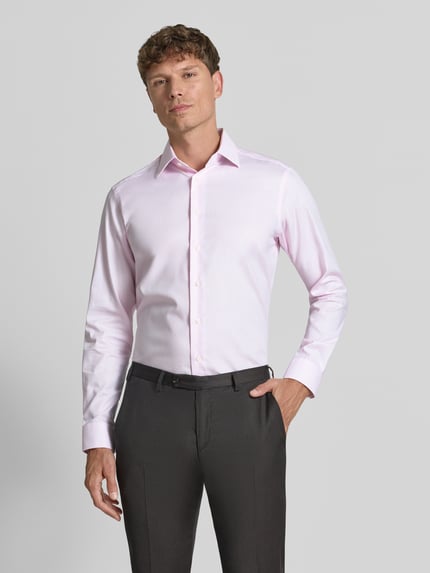 Männermodel trägt Regular Fit Business-Hemd mit Kentkragen von Christian Berg Men in Hellrosa, reine Baumwolle, Ganzkörperansicht von vorne.