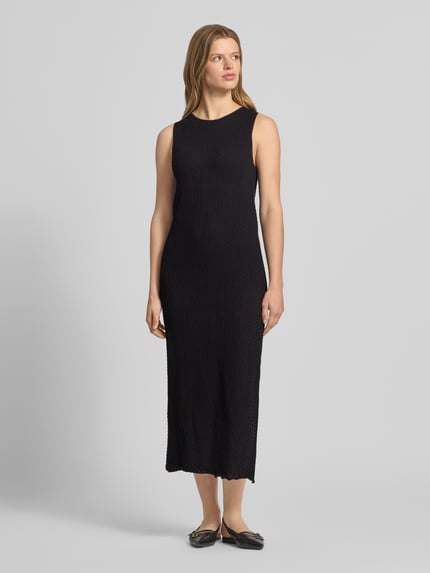 Frauenmodel trägt Maxikleid mit Rundhalsausschnitt Modell 'ZURI' von JJXX aus reine Baumwolle, körpernaher-Schnitt, schwarze Farbe, Ganzkörperansicht von vorne. Rückenlänge bei Größe S: 131 cm, Brustweite bei Größe S: 45 cm.
