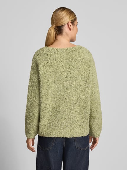 Frauenmodel trägt Cardigan mit V-Ausschnitt Modell 'So44fia' von ZABAIONE, hellgrün, grobe Textur, gerader Schnitt, Ganzkörperansicht Rückansicht. Material-Mix mit Viskose-Anteil, Rückenlänge bei Größe S/M 56 cm, Ärmellänge 47 cm.