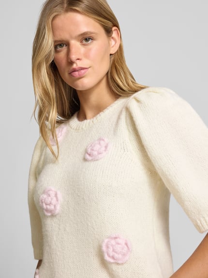 Frauenmodel trägt Regular Fit Shirt mit Stickerei Modell 'AYA' von PIECES in Creme mit rosa Akzenten, Damen Shirt, Nahaufnahme Oberkörper.
