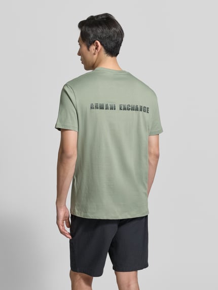 Männermodel trägt T-shirt met logo en ronde hals van ARMANI EXCHANGE, puur katoen, regular fit, ruglengte maat M 82 cm, Ganzkörperansicht Rückansicht.